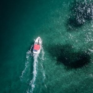 A little motorboat moving forward in the sea shot from above
