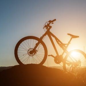 Silhouette Mountain biking on the rock at sky sunset