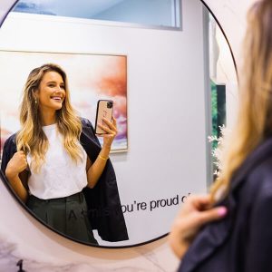 A woman in dental boutique taking a picture of her beautiful smile