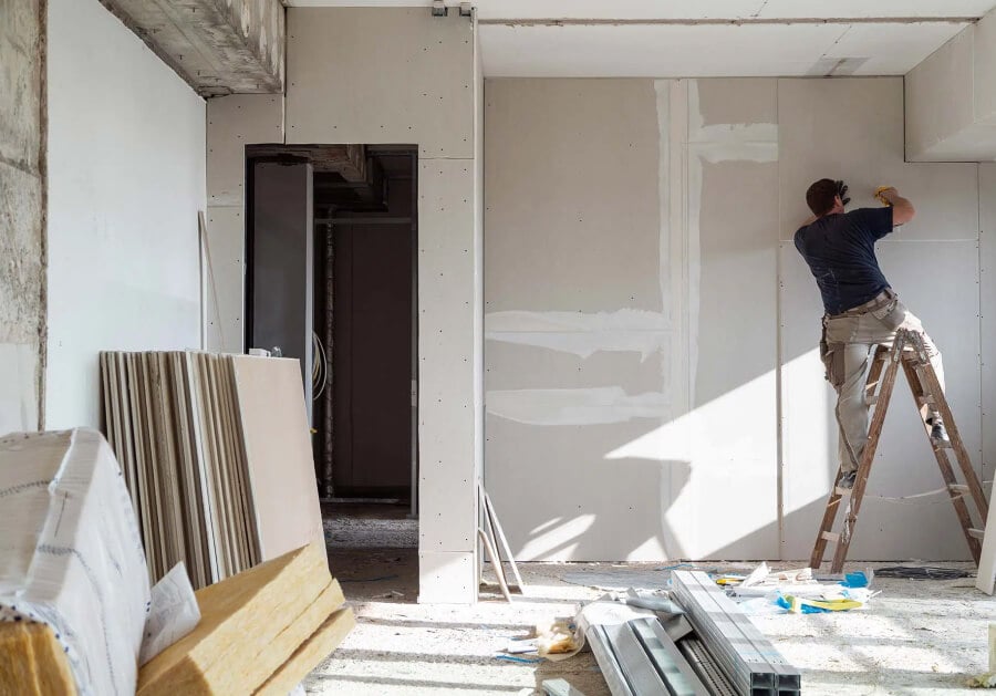 A man on a ladder renovating his family home